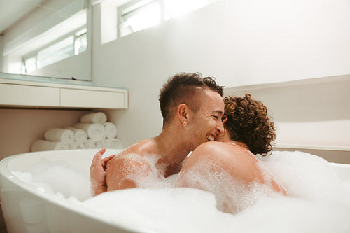 Lovely queer couple enjoying a romantic bubble bath together