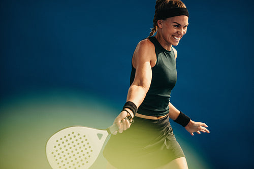 Female player takes winning shot in padel tournament