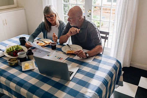 Senior couple discussing finances at the breakfast table