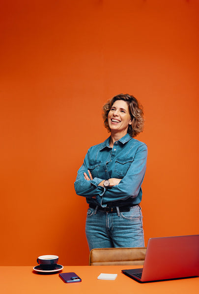 Confident female creative in a minimalist orange office