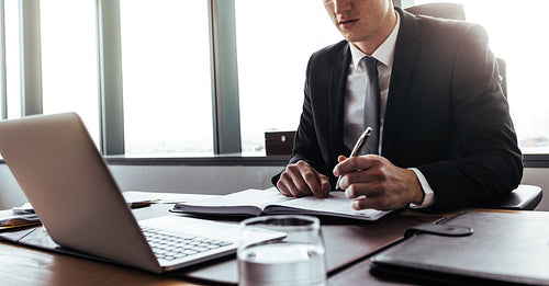 Corporate professional making notes in office