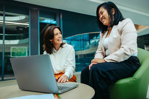 Female colleagues discussing growth and finance strategies in a modern corporate office setting