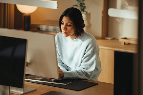 Modern office workspace with woman working at her desktop computer