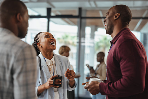 Business colleagues laughing and enjoying a casual coffee break together