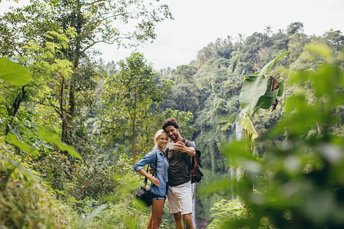 Young tourists taking selfie in the forest