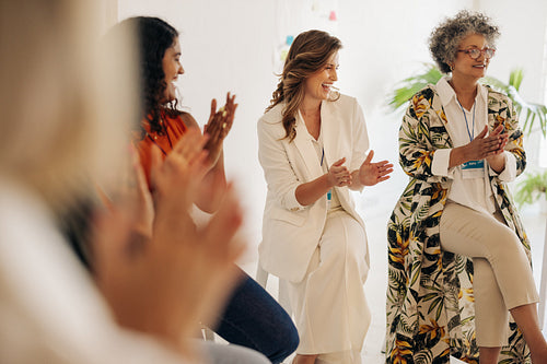 Smiling businesswomen applauding during a conference meeting