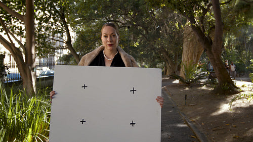 Glamorous woman holding a blank sheet at the park
