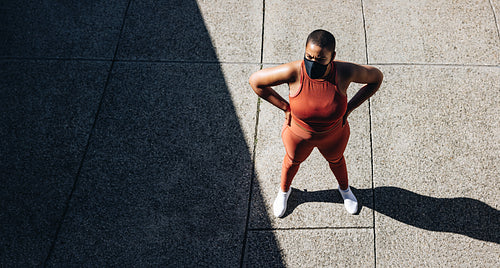 Plus size woman taking break from workout outdoors