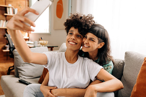 Romantic lesbian couple taking a selfie at home