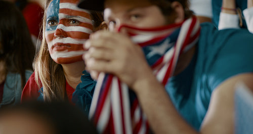 American soccer fans watching game nervously from stands