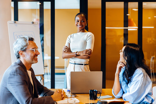 Confident businesswoman leading a meeting with colleagues around a table