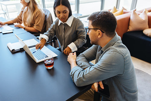 Colleagues discussing a project at a table in an office setting