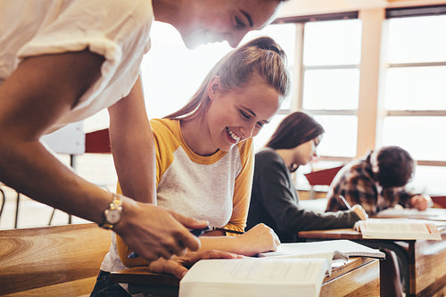 High school teacher helping student in classroom