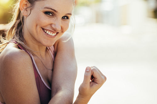 Smiling female athlete doing workout outdoors