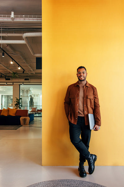 Happy businessman standing in a co-working space