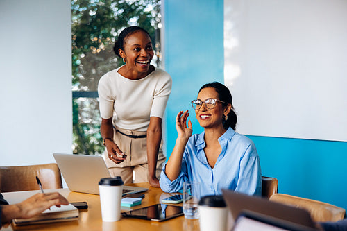 Two women engaging in a lively discussion during a meeting