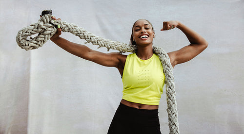 Fitness woman flexing biceps after cross training