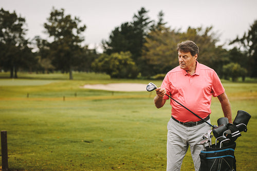 Golfer selecting appropriate club