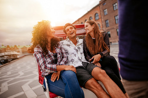 Cheerful teenage friends on tricycle