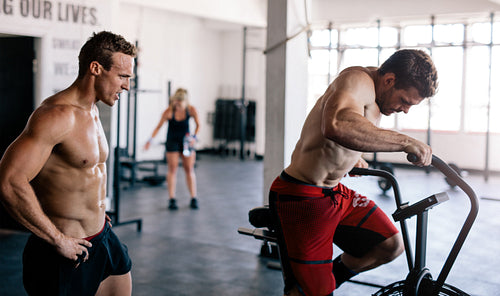 Fitness man exercising in gym with coach