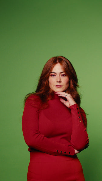 Confident woman smiles, happy and posing in studio with green screen