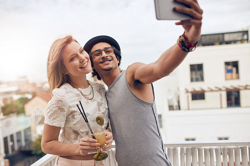 Friends taking a selfie at their outdoor rooftop party