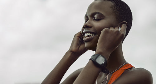 Female relaxing listening to music over headphones after workout