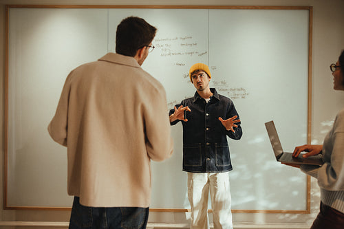 Coworkers discuss business planning at a whiteboard