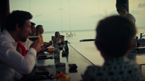 Chef preparing a spectacular flaming dish for an appreciative group at a luxury restaurant