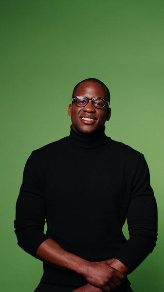 Man in black turtleneck laughs on green screen background