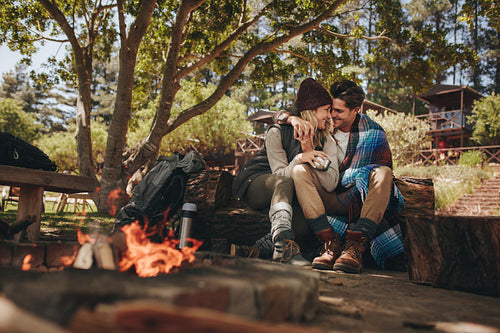 Couple in love sitting near a bonfire
