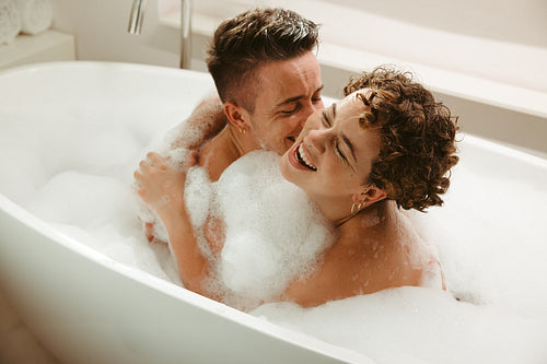 Happy young queer couple having fun in the bathtub