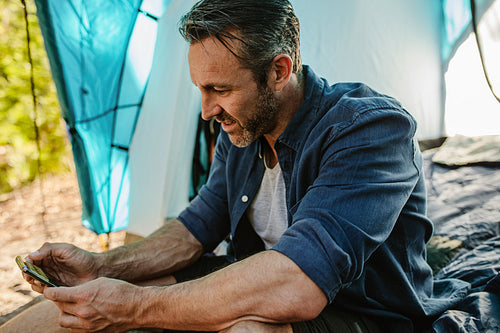 Camper using smart phone at campsite