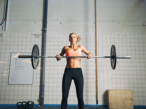 Crossfit young woman lifting heavy weights 