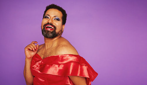 Beautiful genderqueer in shiny female outfit