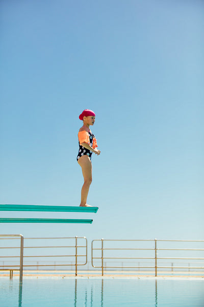 Girl learning to dive into the pool