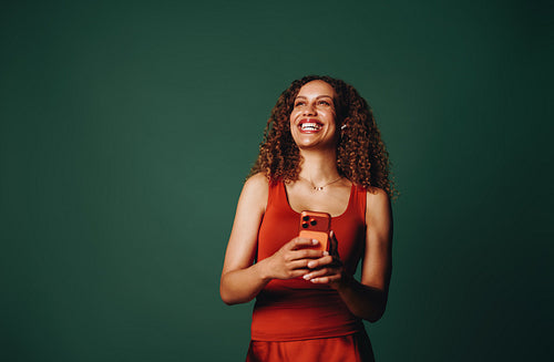 Woman using smartphone in studio for mobile communication and brand color identity