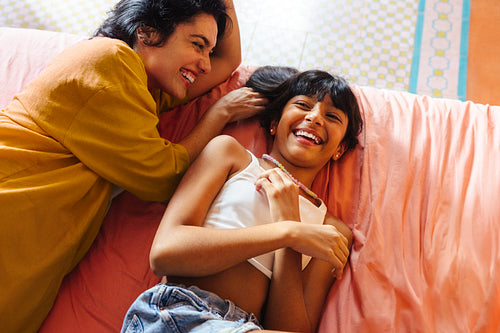 Happy family moment between mother and daughter relaxing and laughing together