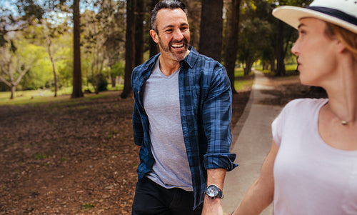 Happy couple walking through autumn park