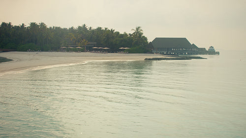 Serene tropical island resort beach with calm ocean water in the peaceful morning light