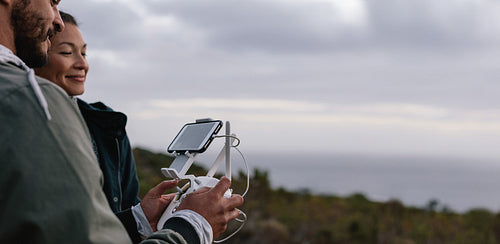 Young couple navigating a flying drone