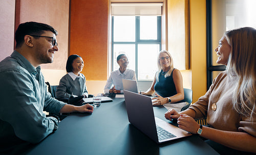 Team of professionals in a meeting discussing ideas in a modern office