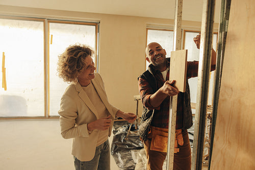 Happy home renovation team: Collaborative interior designer and contractor improving a home's interior