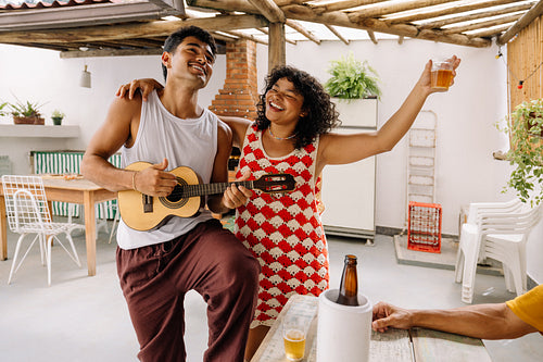 Friends playing cavaquinho and enjoying pagode music at home in Rio de Janeiro