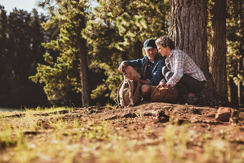 Mature couple using a compass on a hike
