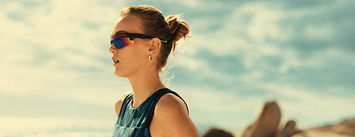 Female athlete playing beach volleyball championship under summer skyscape