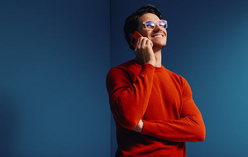 Creative businessman chatting on phone in vibrant monochromatic studio setting