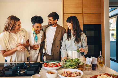 Friends enjoying food and drinks together in a warm home atmosphere