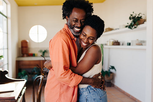 Affectionate married couple holding each other lovingly, sharing a warm hug