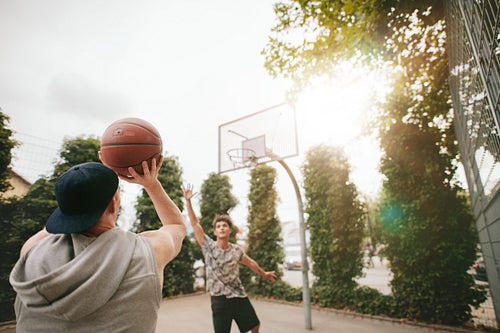 Streetball players on court playing basketball.